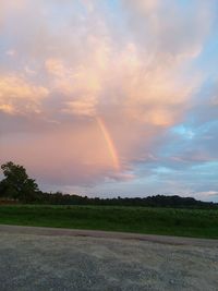 Scenic view of field against rainbow in sky