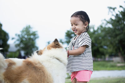 Portrait of young woman with dogs on field