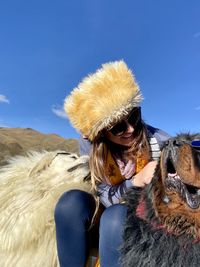 Woman wearing hat on desert against sky