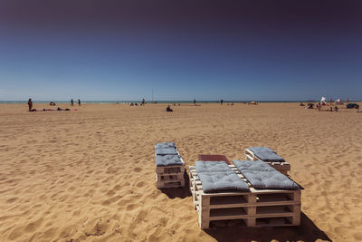 Wooden chairs with cushions on sandy beach, bibione, veneto, italy