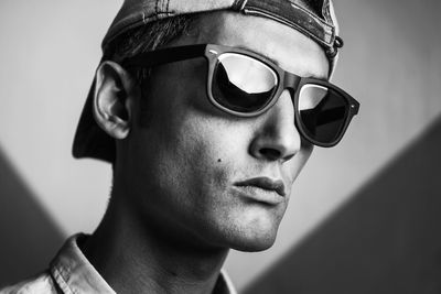 Close-up of serious man wearing sunglasses and cap