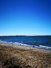 Scenic view of sea against clear blue sky