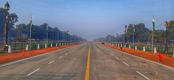 Empty road against sky in city