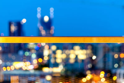 Defocused image of illuminated bridge in city at night