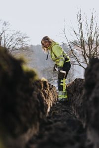 Young female worker digging trench