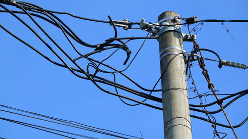 Low angle view of electricity pylon against clear sky