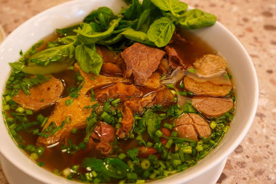 Pho bo or vietnamese soup with beef and meat balls served in a white bowl at the restaurant. 