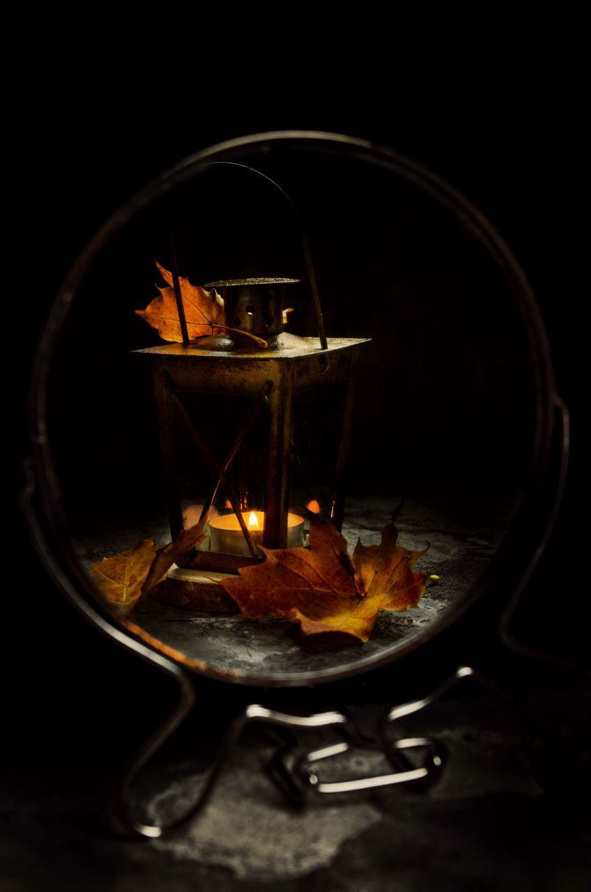 CLOSE-UP OF LIT CANDLE ON TABLE