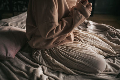 Midsection of man sitting on bed