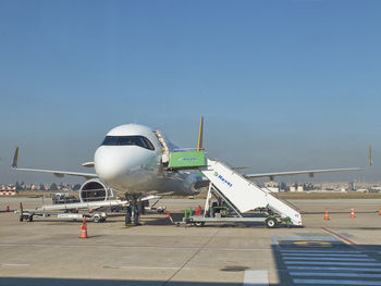 Airplane on runway against sky