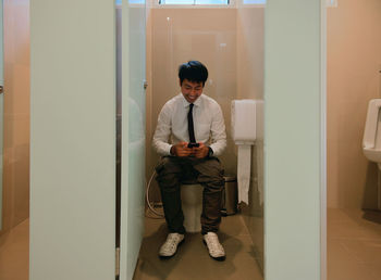 Man using mobile phone in toilet