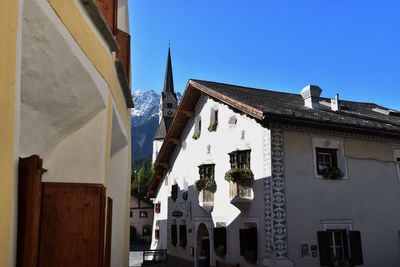 Low angle view of houses against clear blue sky