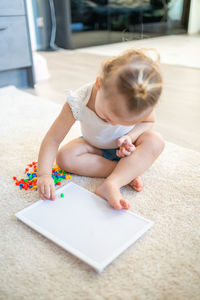 Cute girl playing with multi colored toy at home