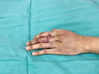 Midsection of woman lying on blue hand