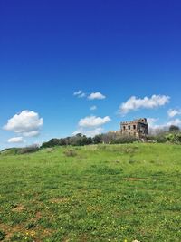 Old ruin on field against blue sky