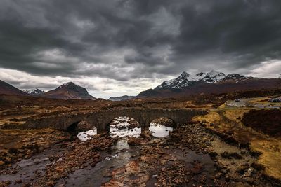 Scenic view of bridge over river against cloudy sky