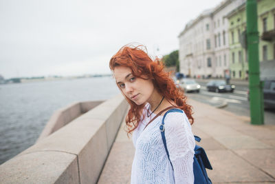 Portrait of beautiful young woman against built structure