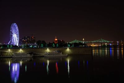 Illuminated buildings by river at night