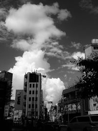 Buildings in city against cloudy sky