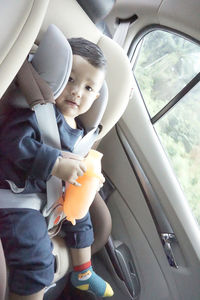 Cute boy sitting in car