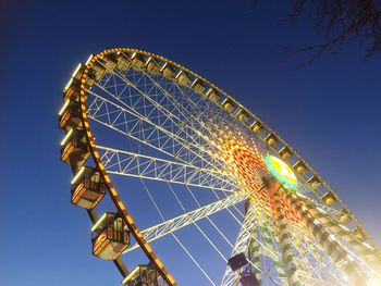 Low angle view of ferris wheel against clear blue sky