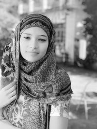 Portrait of woman wearing scarf in city