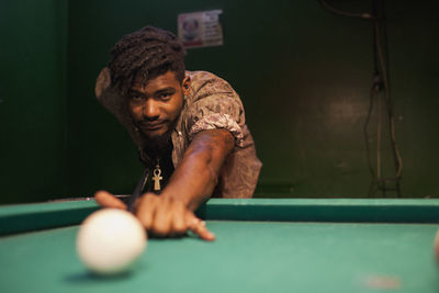 A young man playing pool.