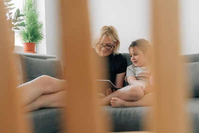 Woman and girl using digital tablet at home