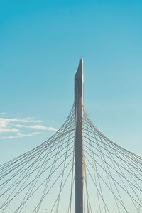 Low angle view of suspension bridge against clear blue sky