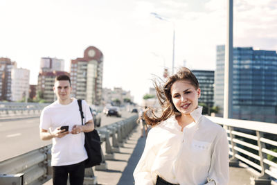 Young couple standing in city against sky