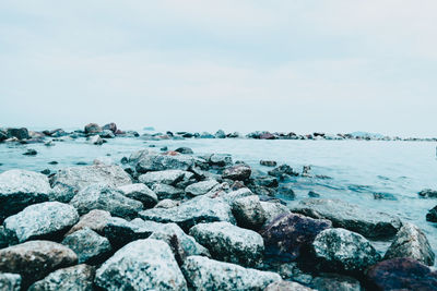 Rocks on beach against sky