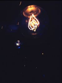 Close-up of illuminated light bulb in darkroom