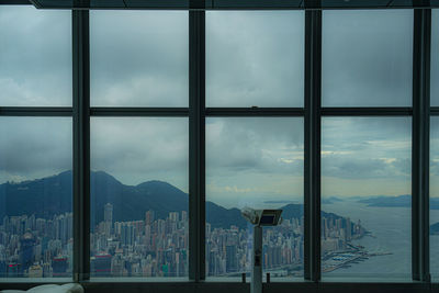 Buildings against sky seen through glass window