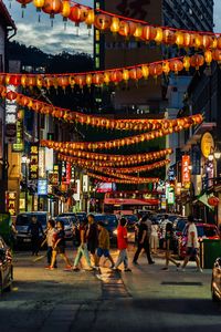 People walking on illuminated street at night