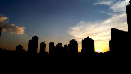 Silhouette buildings against sky during sunset