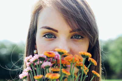 Close-up portrait of young woman with flowers