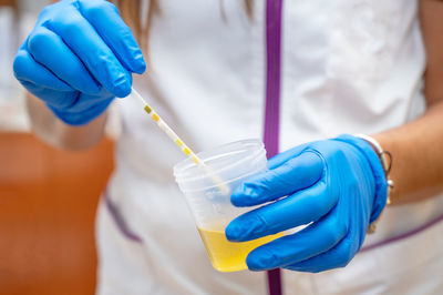 Midsection of scientist holding dentures