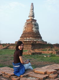 Portrait of young woman sitting against temple