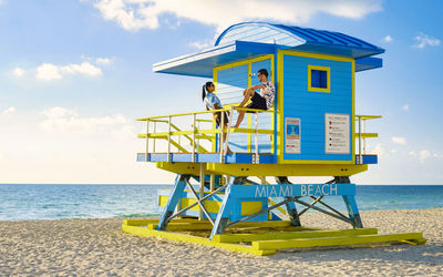 Lifeguard hut on beach against sky