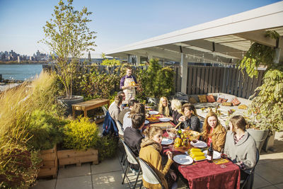 High angle view of friends having meal at outdoor table during garden party