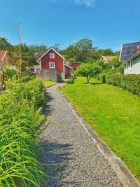 House on field by building against sky