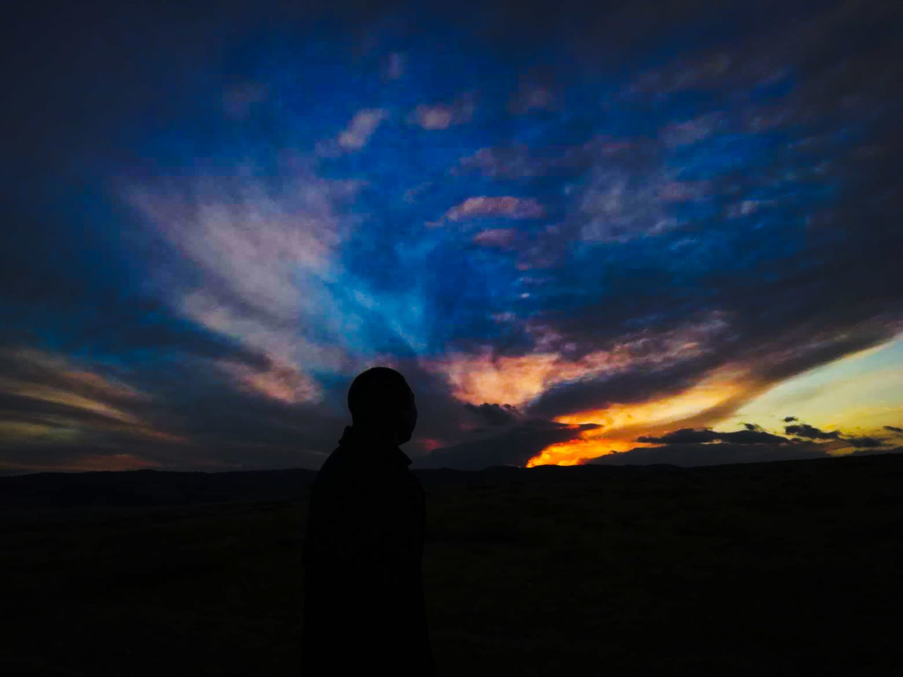 sky, cloud - sky, silhouette, standing, one person, beauty in nature, sunset, scenics - nature, nature, land, tranquility, tranquil scene, lifestyles, real people, adult, rear view, landscape, leisure activity, waist up, outdoors, depression - sadness