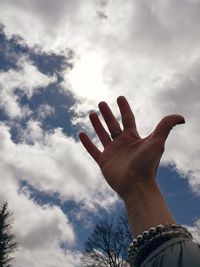 Low angle view of hand against sky