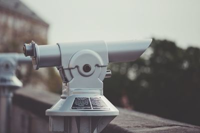 Close-up of coin-operated binoculars against sky