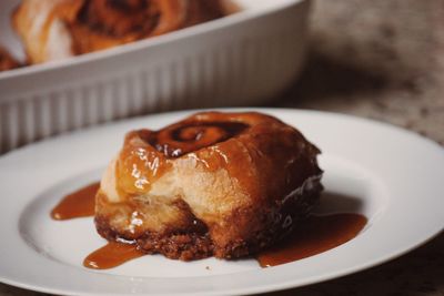 Close-up of cinnamon roll with honey in table