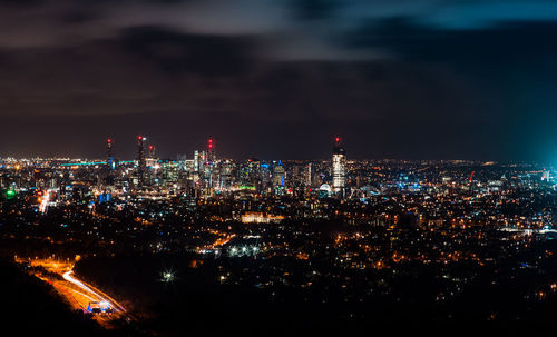 Illuminated cityscape against sky at night