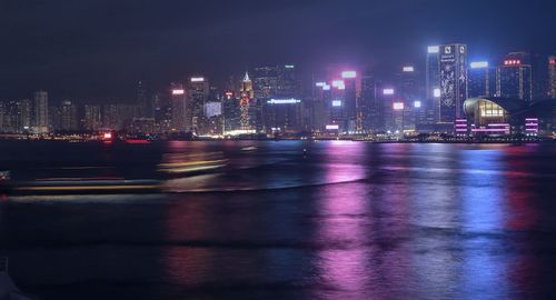 High angle view of river with illuminated light reflection by city at night