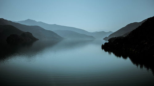 Scenic view of lake and mountains against clear sky