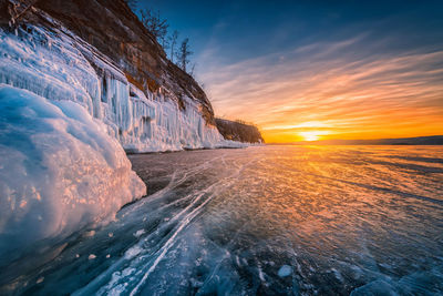 Scenic view of frozen sea against sky during sunset