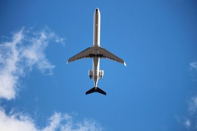 Low angle view of airplane flying against sky